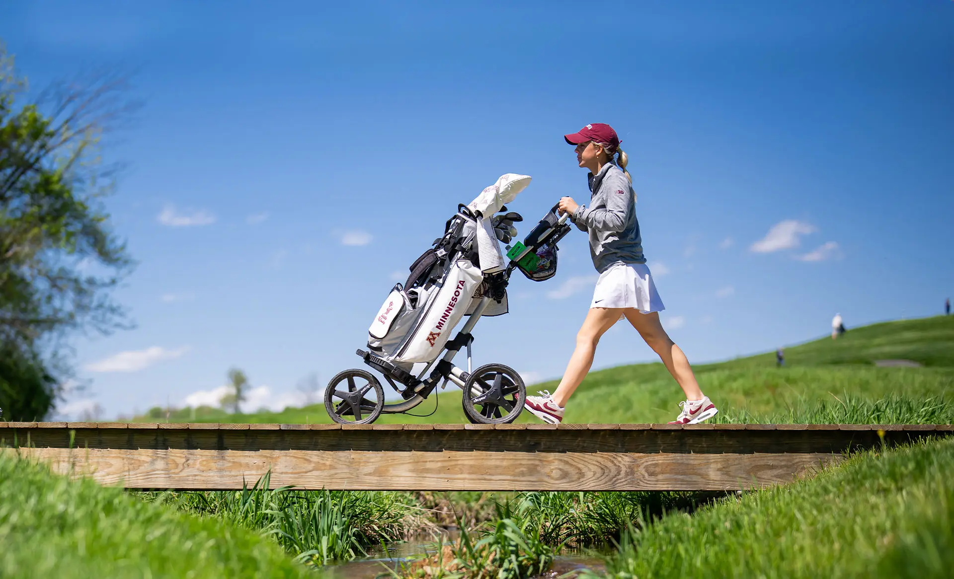 golfer pushing her golf bag