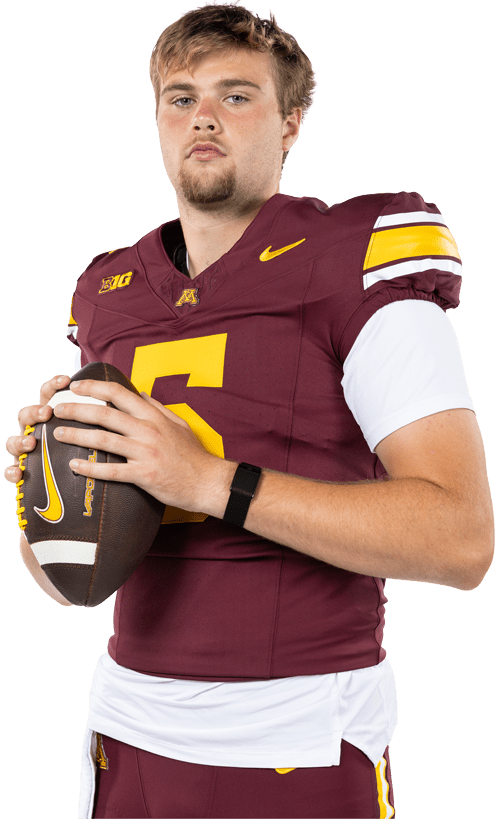 Football player posing in uniform holding football