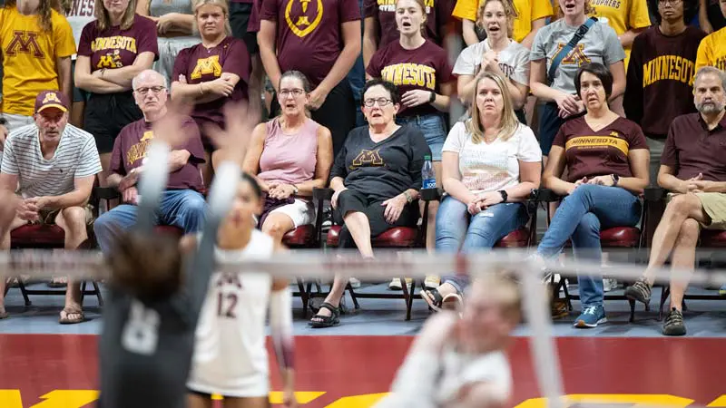 Fans watching volleyball game from courtside seats