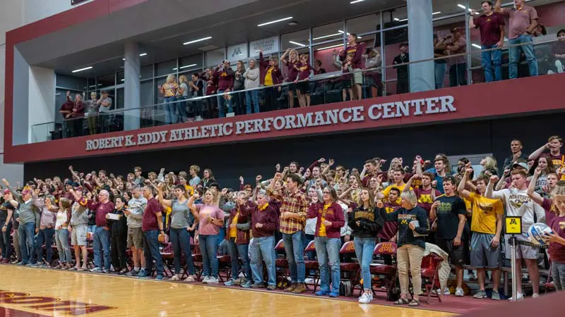 Fans watching volleyball game from courtside seats